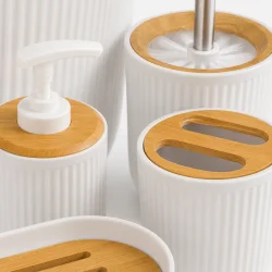 Bambusdetaljer p� hvidt badev�relsestilbeh�r med riflet overflade, s�bedispenser, toiletb�rste og tandb�rsteholder