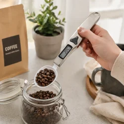 Digital m�leske med LCD i brug til pr�cis vejning af ingredienser i k�kken