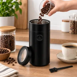 Elektrisk kaffekv�rn i k�kkenmilj� med kaffeb�nner, der h�ldes i kv�rnen.