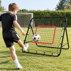 Fodbold rebounder i brug til skudtr�ning p� gr�s med bold og spiller