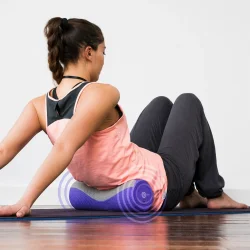Massage roller med vibration i brug til ryg og l�nd p� yogam�tte