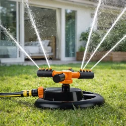 Roterende sprinkler med 3 arme i brug p� gr�spl�ne med j�vn havevanding
