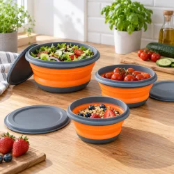 Sammenklappelige sk�le med mad p� et k�kkenbord, vist i forskellige st�rrelser med l�g ved siden af.