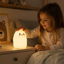 Sengelampe til b�rn i brug p� b�rnev�relse hvor barn anvender bl�d pingvin natlampe med varmt LED lys ved sengetid